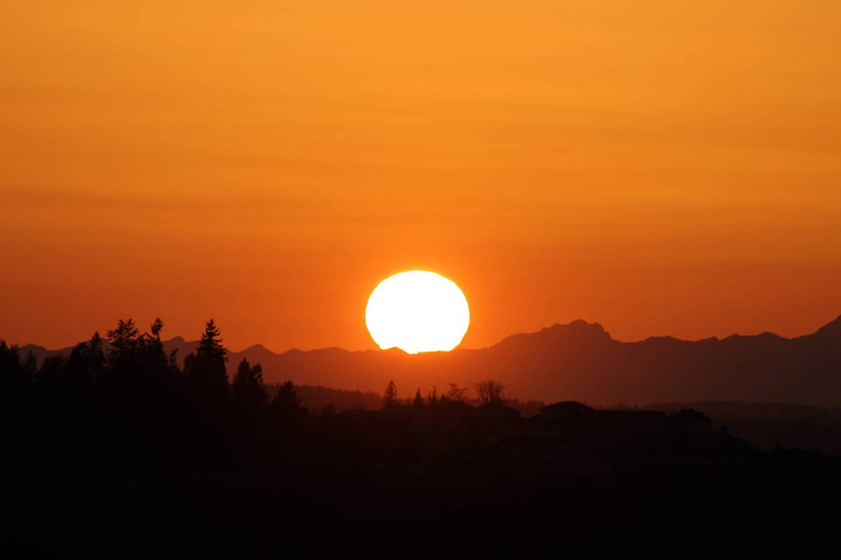 Silhouette photo of hills in front of a sunset.